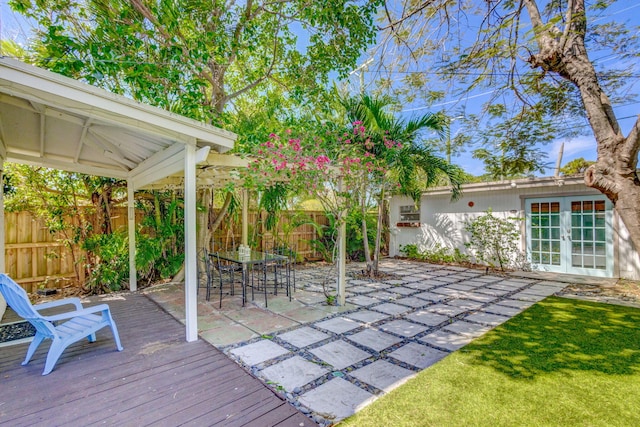 535 28th St, West Palm Beach, FL 33407 - wooden terrace featuring french doors, a fenced backyard, and a patio