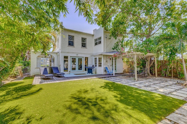 535 28th St, West Palm Beach, FL 33407 - back of house featuring french doors, a wooden deck, stucco siding, and a patio area