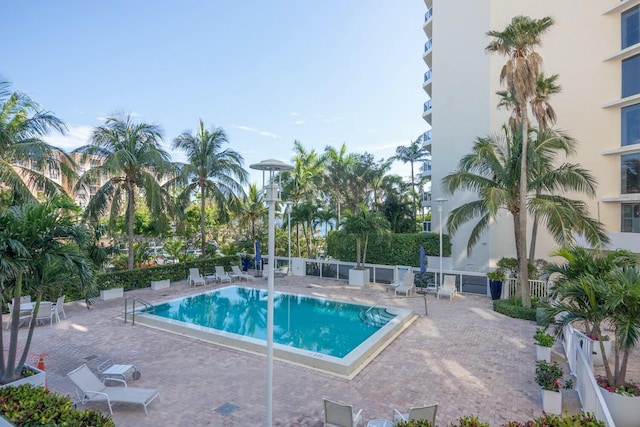 pool with a patio area and fence