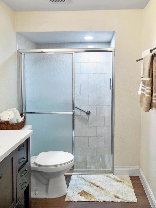 full bath with a stall shower, wood finished floors, and vanity