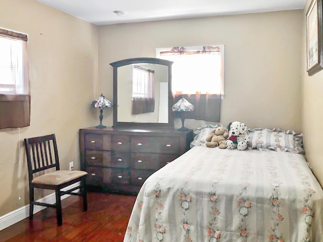 bedroom with wood finished floors and baseboards