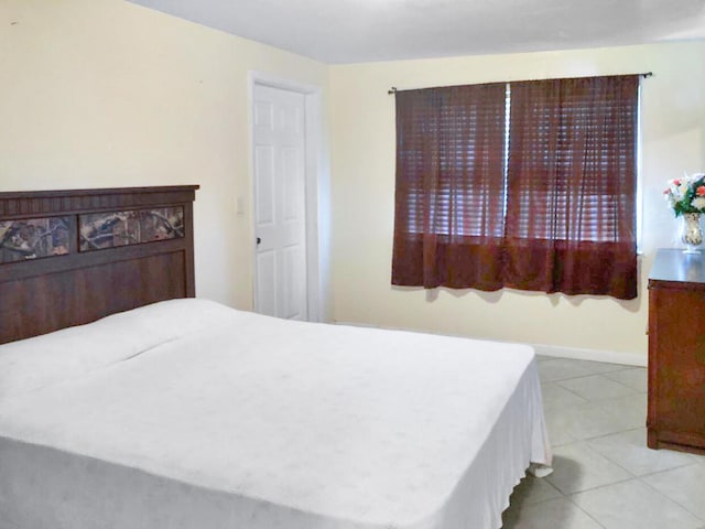 bedroom featuring tile patterned flooring and baseboards