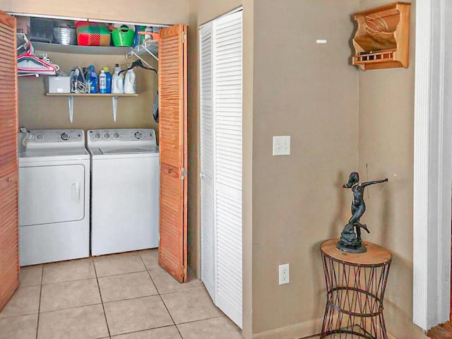 clothes washing area featuring laundry area, washer and clothes dryer, and tile patterned floors