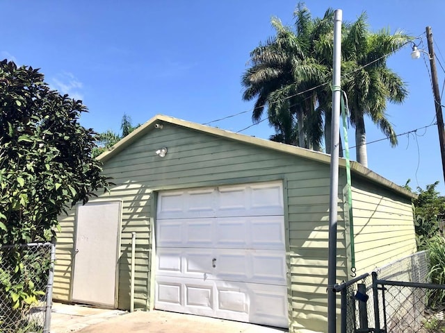 detached garage featuring fence