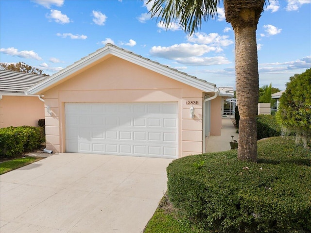 view of front of home with a garage, driveway, and stucco siding