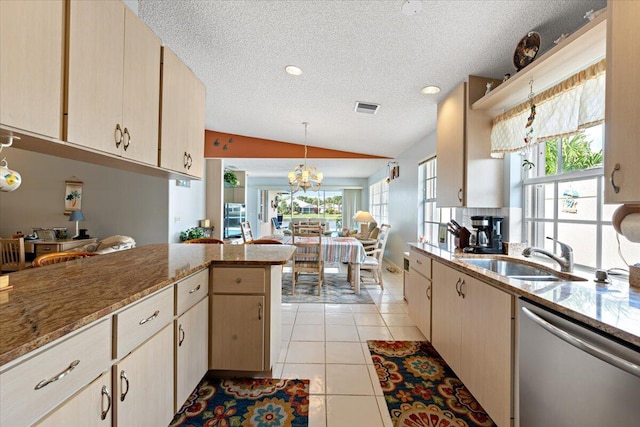 kitchen featuring light tile patterned flooring, a sink, visible vents, vaulted ceiling, and dishwasher