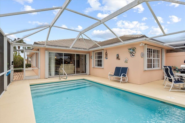 pool featuring glass enclosure and a patio