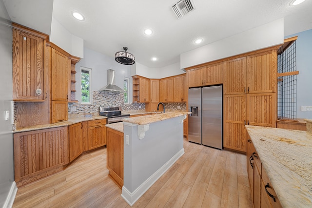 kitchen with visible vents, wall chimney range hood, light wood-style floors, stainless steel appliances, and open shelves