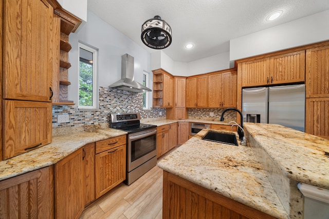 kitchen with open shelves, appliances with stainless steel finishes, a sink, and wall chimney range hood