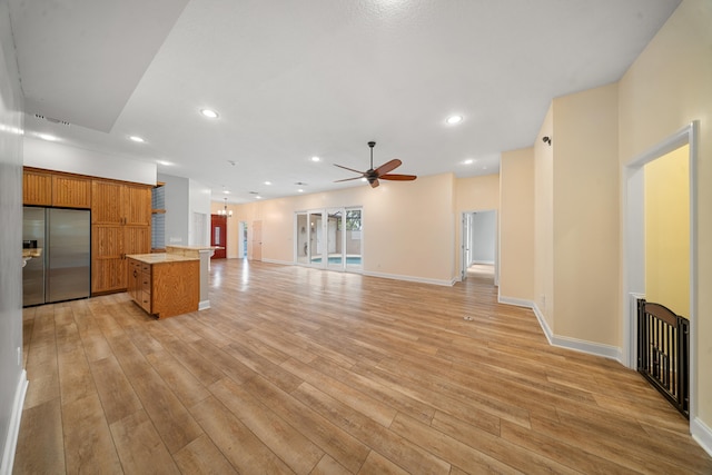 kitchen featuring light countertops, stainless steel refrigerator with ice dispenser, light wood finished floors, and a center island