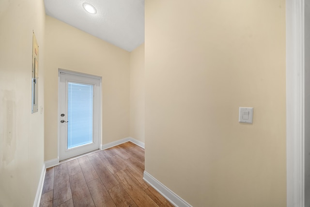 hallway featuring baseboards and wood finished floors