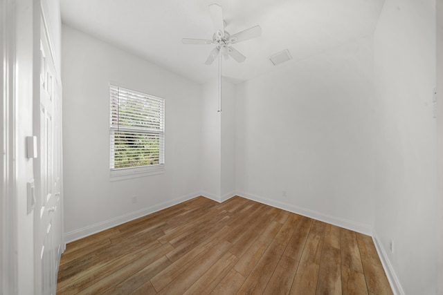 empty room featuring hardwood / wood-style floors, baseboards, and ceiling fan