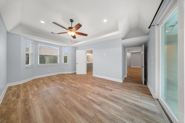 unfurnished bedroom featuring recessed lighting, light wood-type flooring, a raised ceiling, and baseboards