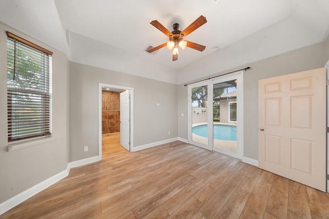 spare room featuring baseboards, plenty of natural light, light wood-style floors, and ceiling fan