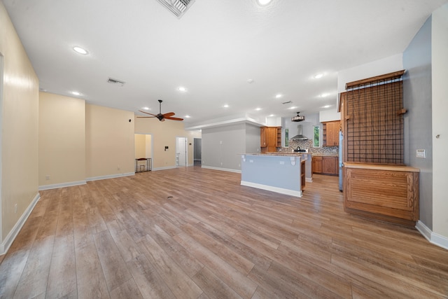 unfurnished living room featuring light wood-style floors, visible vents, and ceiling fan