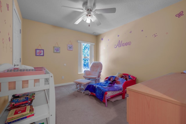 carpeted bedroom featuring a ceiling fan and a textured ceiling