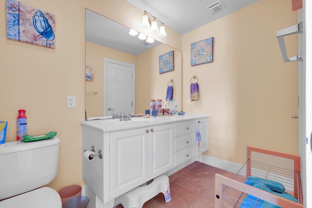 bathroom featuring visible vents, toilet, vanity, tile patterned flooring, and baseboards