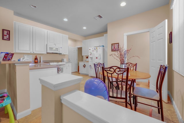 kitchen featuring white appliances, visible vents, white cabinets, a peninsula, and recessed lighting