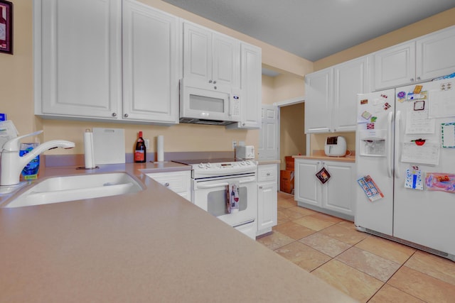 kitchen featuring light countertops, white appliances, a sink, and white cabinets