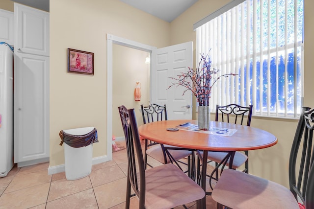 dining space featuring light tile patterned floors and baseboards