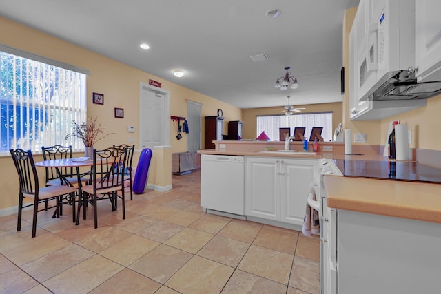 kitchen with white cabinets, a sink, ceiling fan, white appliances, and a peninsula