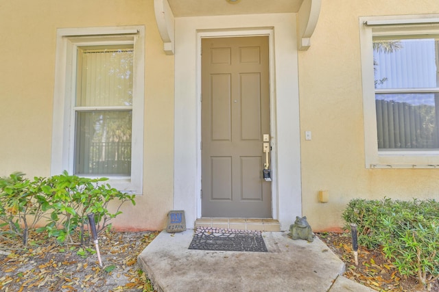 property entrance with stucco siding