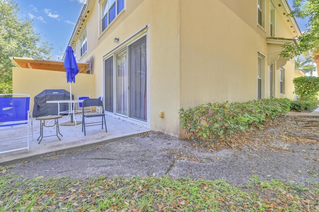 view of side of property featuring a patio area and stucco siding