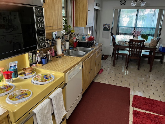 kitchen with light tile patterned floors, white appliances, light countertops, and a sink