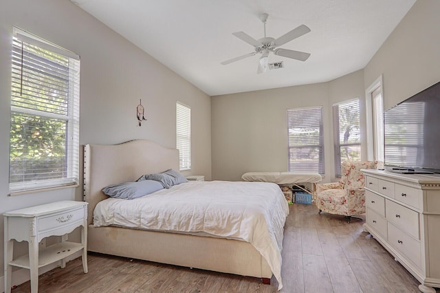 bedroom with visible vents, light wood-style flooring, a ceiling fan, and multiple windows