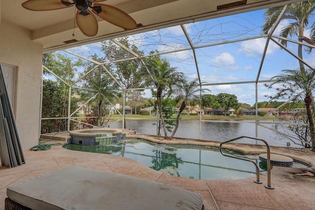 view of pool with a water view, a ceiling fan, a pool with connected hot tub, glass enclosure, and a patio area