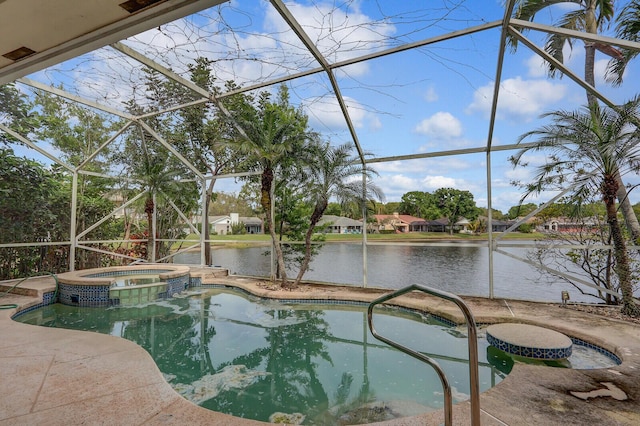 view of swimming pool featuring a patio area, glass enclosure, a pool with connected hot tub, and a water view