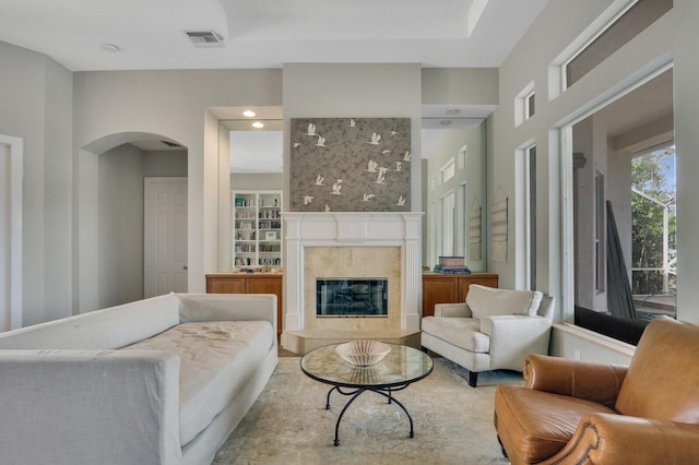 living room with arched walkways, visible vents, and a fireplace