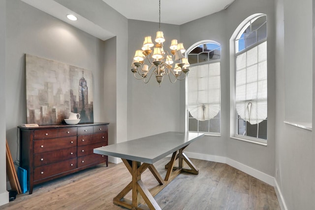 dining room featuring baseboards, light wood-style floors, and an inviting chandelier