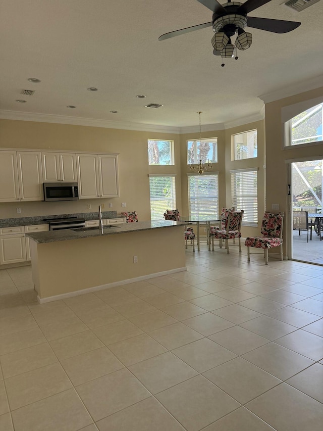 kitchen featuring light tile patterned floors, a sink, visible vents, appliances with stainless steel finishes, and crown molding