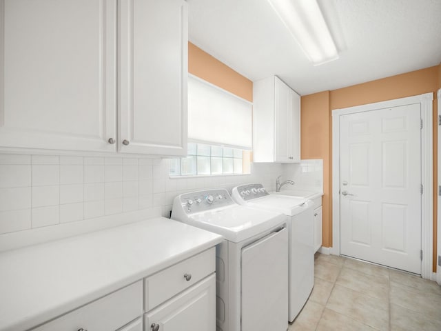 laundry area featuring a sink, cabinet space, light tile patterned floors, and washer and dryer