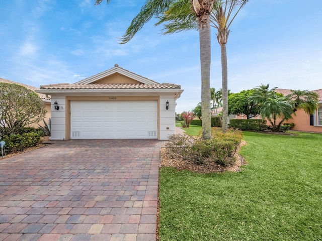 view of front of house with a tiled roof, a front lawn, decorative driveway, and stucco siding