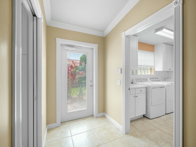 entryway with baseboards, ornamental molding, washer and clothes dryer, and light tile patterned flooring