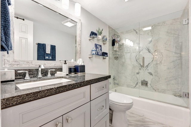 bathroom featuring marble finish floor, shower / bath combination with glass door, vanity, and toilet