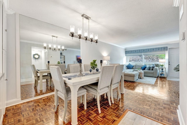 dining room with a chandelier, crown molding, a textured ceiling, and baseboards