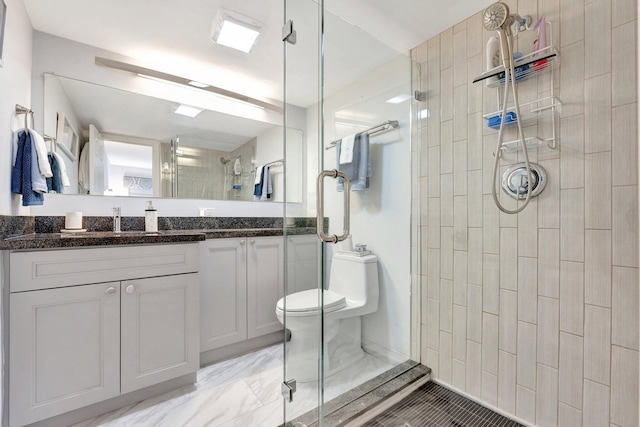 full bathroom featuring toilet, a shower stall, and vanity