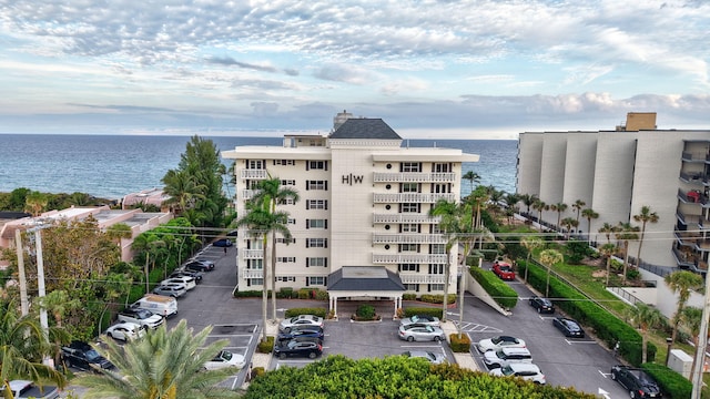 view of property with uncovered parking and a water view