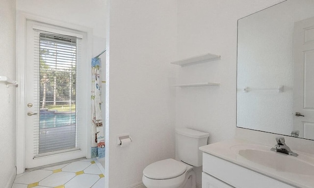 bathroom featuring toilet, curtained shower, and vanity