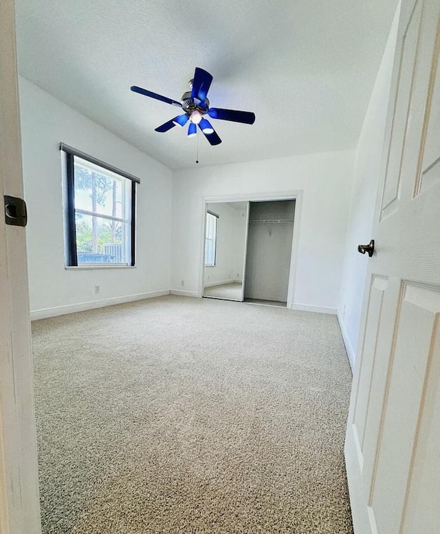 unfurnished bedroom featuring a closet, carpet flooring, ceiling fan, a textured ceiling, and baseboards