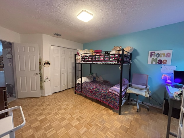 bedroom featuring a textured ceiling, a closet, and visible vents