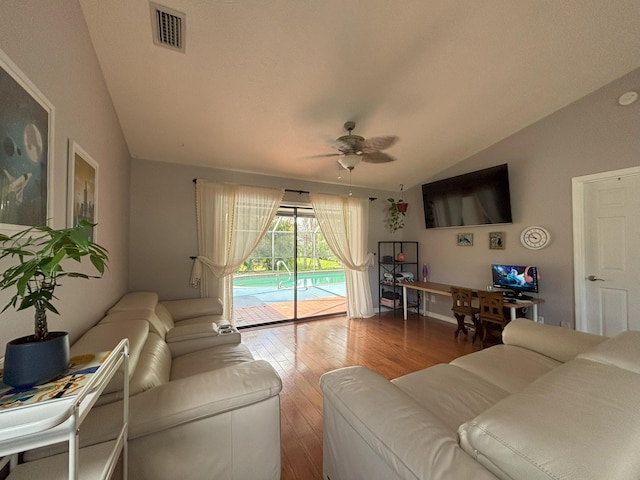 living area with lofted ceiling, a ceiling fan, visible vents, and wood finished floors