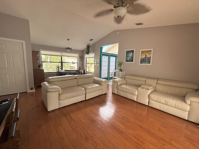 living room with lofted ceiling, wood-type flooring, visible vents, and a ceiling fan