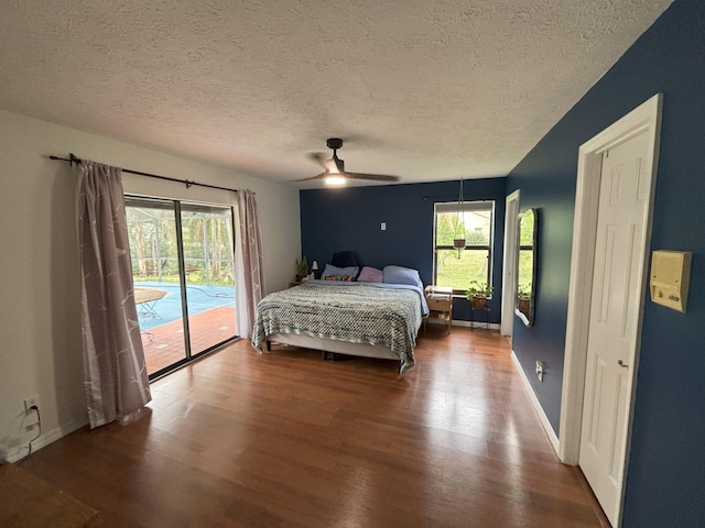 bedroom featuring access to exterior, ceiling fan, a textured ceiling, wood finished floors, and baseboards