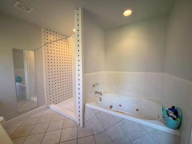 bathroom with a jetted tub, tile patterned flooring, visible vents, and a tile shower