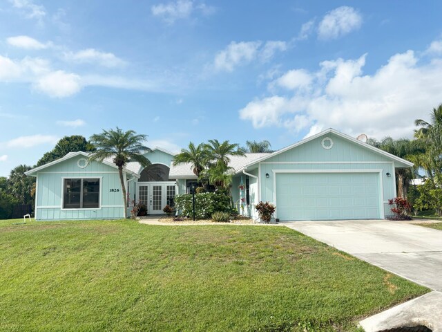 1826 SW Stratford Way, Palm City, FL 34990 - ranch-style house featuring french doors, driveway, an attached garage, and a front lawn