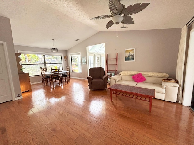 1826 SW Stratford Way, Palm City, FL 34990 - living area with vaulted ceiling, wood finished floors, a ceiling fan, baseboards, and a textured ceiling